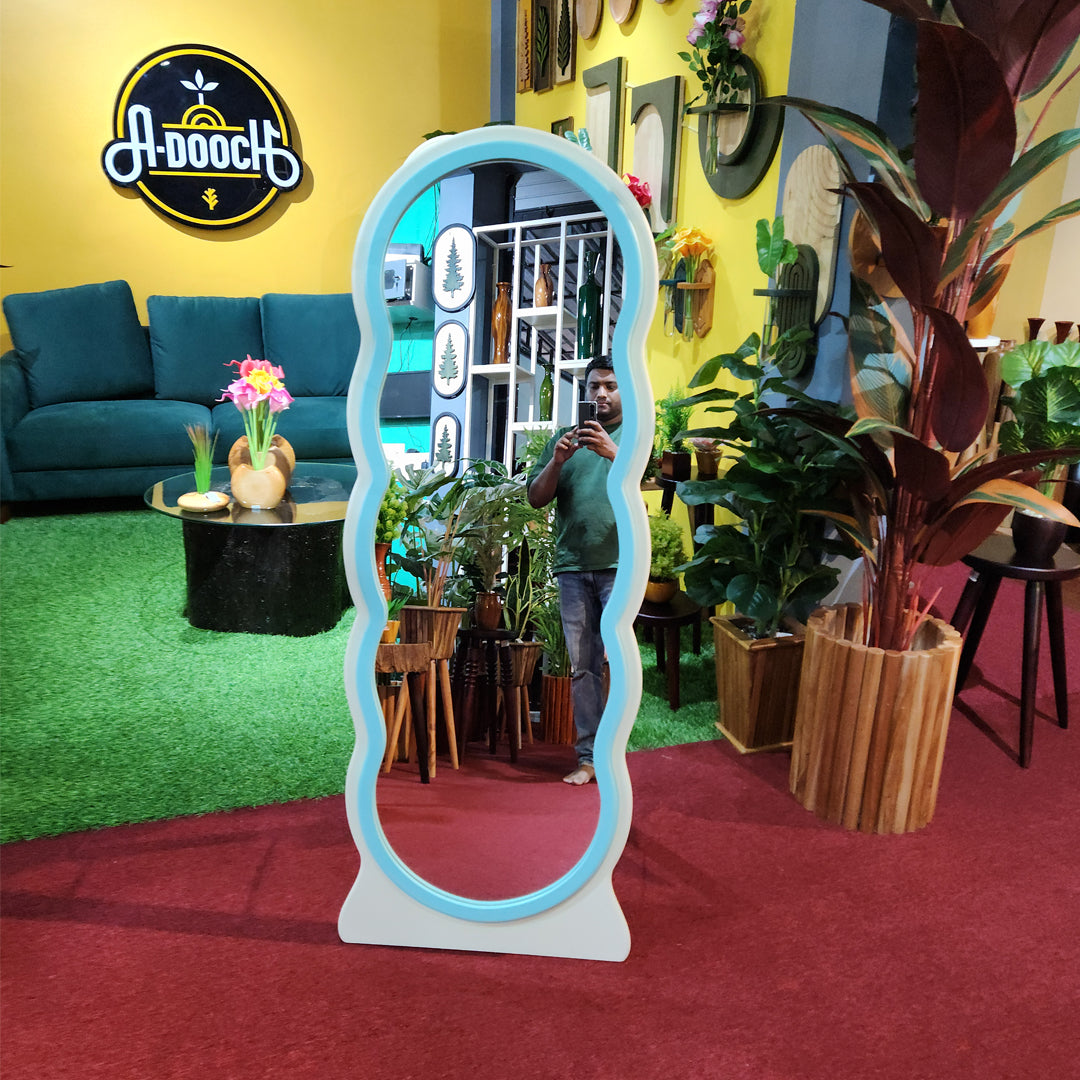 Front view of the Adooch aesthetic full body wavy mirror in the A-Dooch showroom, surrounded by plants and furniture