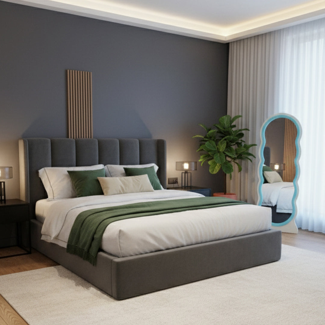 Adooch irregular wavy floor mirror standing in a modern bedroom, reflecting the bed and decor