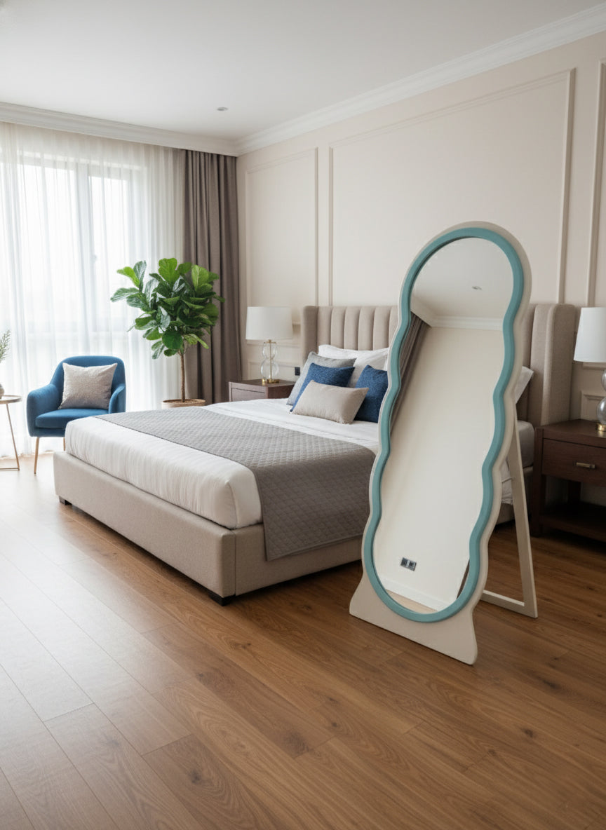 adooch irregular wavy floor mirror standing in a modern bedroom, reflecting the bed and decor